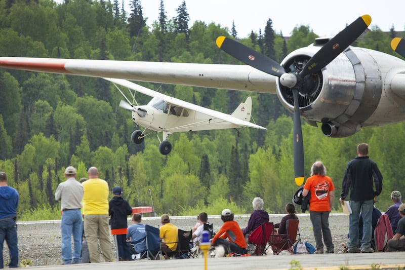 Spectators watch as a Piper J4A demonstrates take off and landings during the Hudson Memorial Fly-in at Talkeetna on May 15. Photo by Rob Stapleton/Alaskafoto