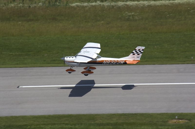 Race 23, with Dan Bean at the controls, in hot pursuit of Race 53. The Cessna 150 K Aerobat has a 100 horsepower engine, quite a bit more powerful than Race 53’s 85-horse Continental, but the Cessna has a more draggy design than Race 53. It was anyone’s guess which plane would be faster. Until the awards ceremony, even the two pilots weren’t sure who won the heat. (Photo by Lisa F. Bentson)