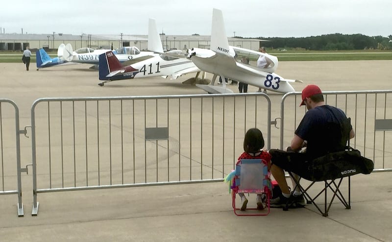 Children love air racing! Here a young girl and her father grab a bite of lunch while watching the racers prepare their planes. (Photo by William E. Dubois)