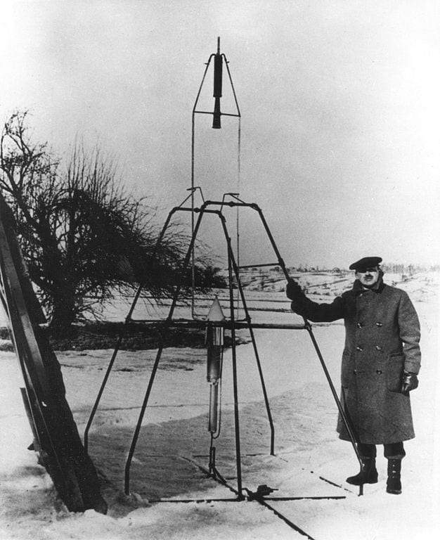 Robert Goddard, bundled against the cold weather of March 16, 1926, holds the launching frame of his most notable invention — the first liquid-fueled rocket. (NASA Photo) 