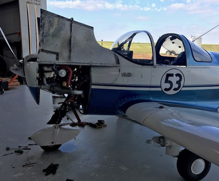 Not looking ready to race, Race 53 sits with her lower cowl and carburetor removed. The storm has passed, but the plane won’t be flying anytime soon. Note the pool of fuel on the hangar floor. (Photo by William E. Dubois)