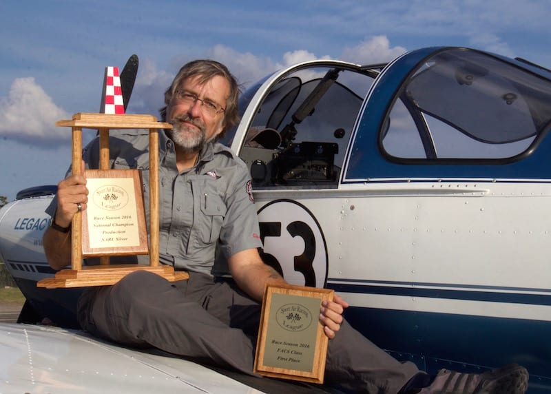 Brand new National (Silver) Champion air racer William E. Dubois displays his season-end trophies with the plane that made it all possible: The 69-year-old Ercoupe N3975H, a.k.a. Race 53 (known to family and friends as “Tessie”). The high final ranking of the Ercoupe this season is proof positive that the League’s motto, “Racing for the rest of us” is valid. (Photo by Lisa F. Bentson)