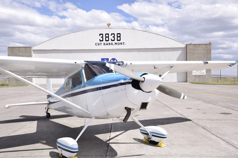 Customs clearance returning to the United States is done on the aircraft parking area outside the Cut Bank main hangar, a landmark on the sprawling World War II era airfield. 