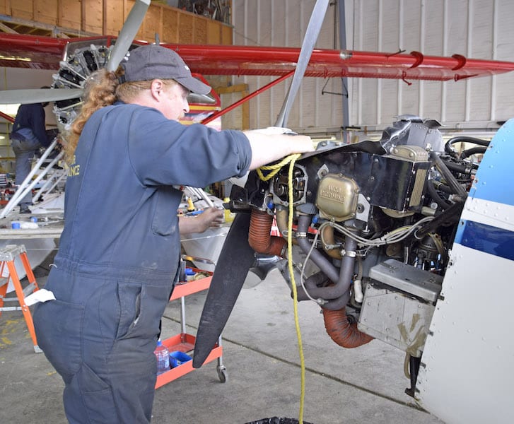 A&P Justin Rogers of Rodan Air Maintenance at Whitehorse prepares to use a length of rope to unstick an exhaust valve on N3245G.